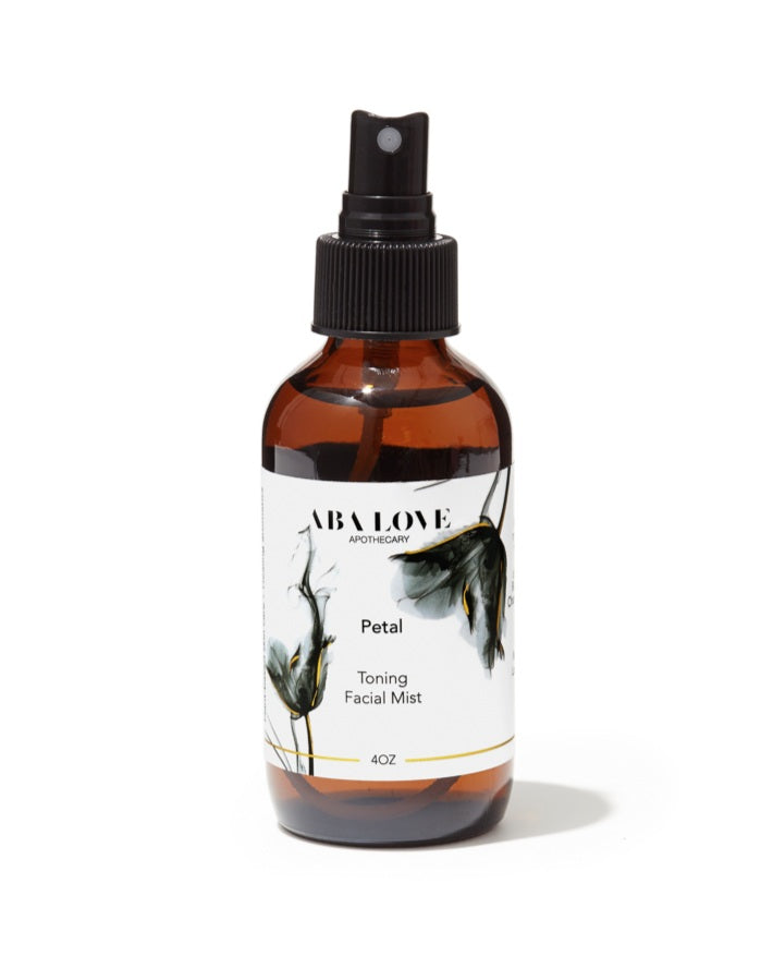 Amber glass bottle with black sprayer mist top. Petal Toning Facial Mist.There is a thin gold line printed on the label.